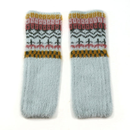 A pair of fluffy, light grey wool socks with a cosy multi-pattern design in mustard yellow, pink, and dark grey near the top, laid flat on a white background.