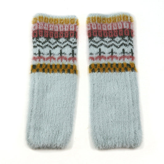 A pair of fluffy, light grey wool socks with a cosy multi-pattern design in mustard yellow, pink, and dark grey near the top, laid flat on a white background.