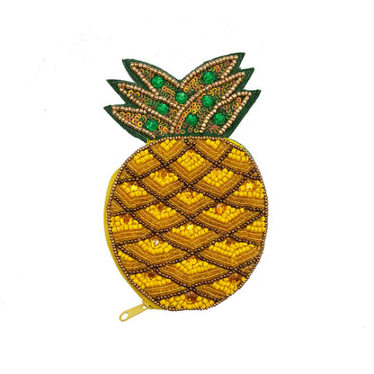 A quirky, pineapple-shaped handbag adorned with beads and sequins, boasting yellow, green, and gold accents on a white background—a perfect vegan-friendly gift for anyone who loves distinctive accessories.