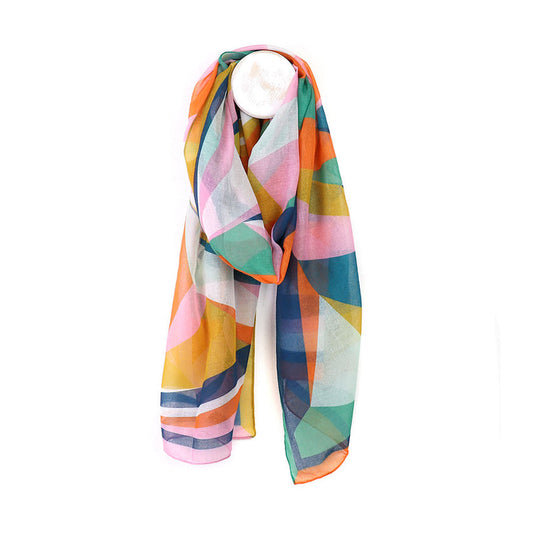 A vibrant summer scarf featuring a geometric pattern in pink, orange, yellow, teal, and blue; this lightweight, vegan-friendly scarf is elegantly draped over a white circular display stand.