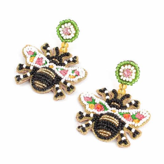 Discover these beaded bee earrings, handcrafted with vibrant beads in black, white, green, and pink. Adorned with floral details and round green bead attachments, they make a stunning addition to any outfit.
