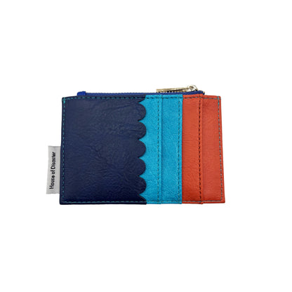 A compact Coral Crab Zip Purse cardholder featuring navy, turquoise and orange panels, scalloped edge detail, a zipped pocket, and a House of Glover fabric label on the left side.