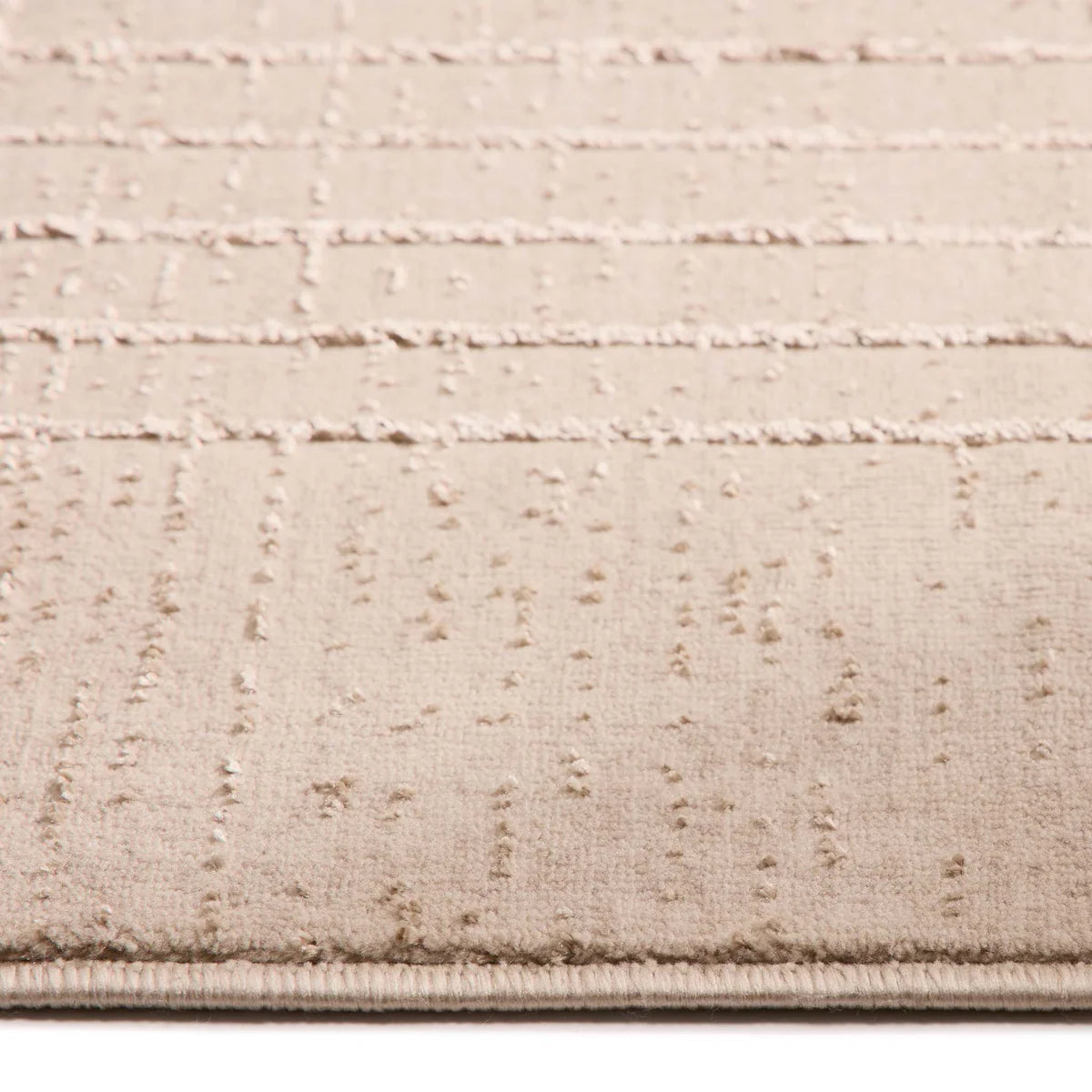 Close-up of the Calacatta Lines Natural Rug, a contemporary polyester rug in beige with a subtle grid design, featuring raised lines and a soft, plush surface.