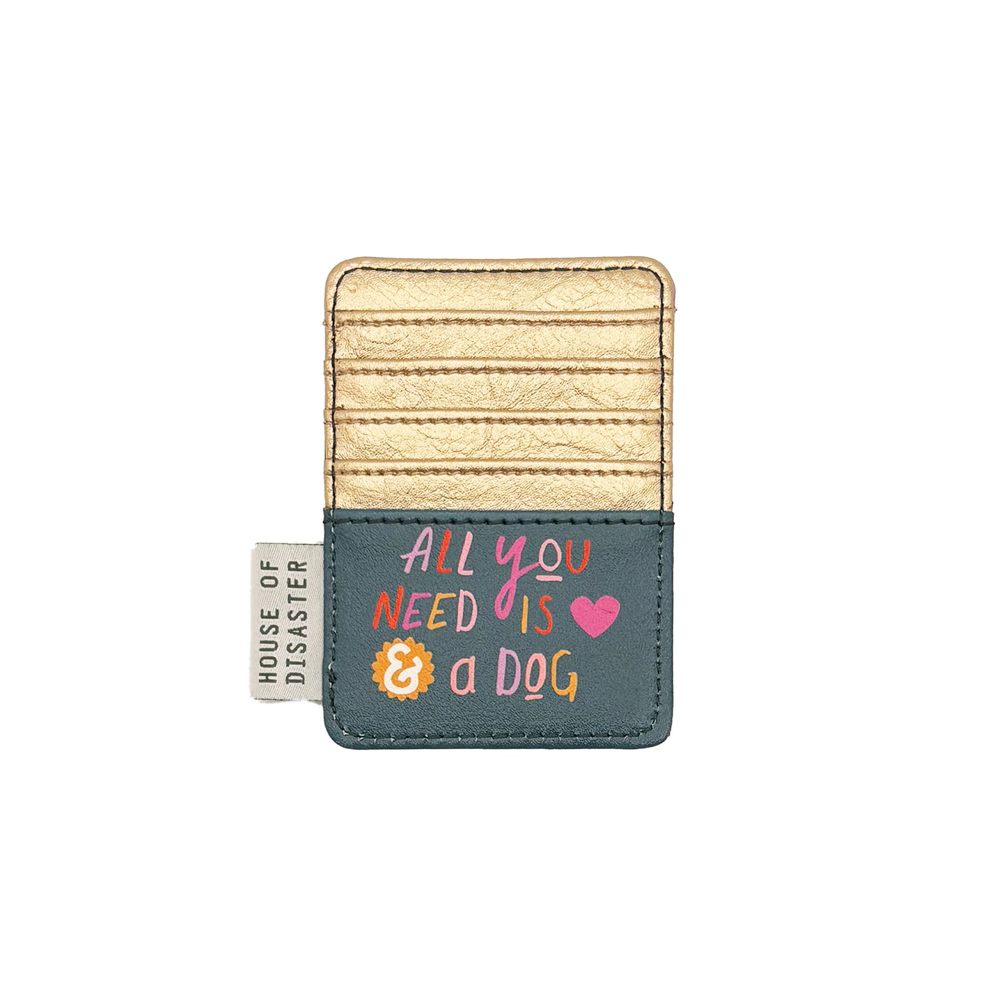 A charming faux leather card holder in gold and teal featuring the phrase "All you need is & a dog and a heart," with a House of Disaster fabric tag on the left side.