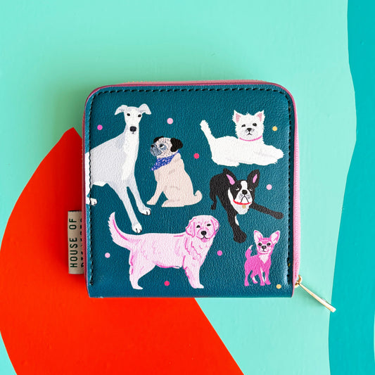 A teal zip purse from the Doghouse collection featuring six dog breeds, pink and purple dots, and a House Of tag—ideal for dog lovers. Set against a multicoloured abstract background.