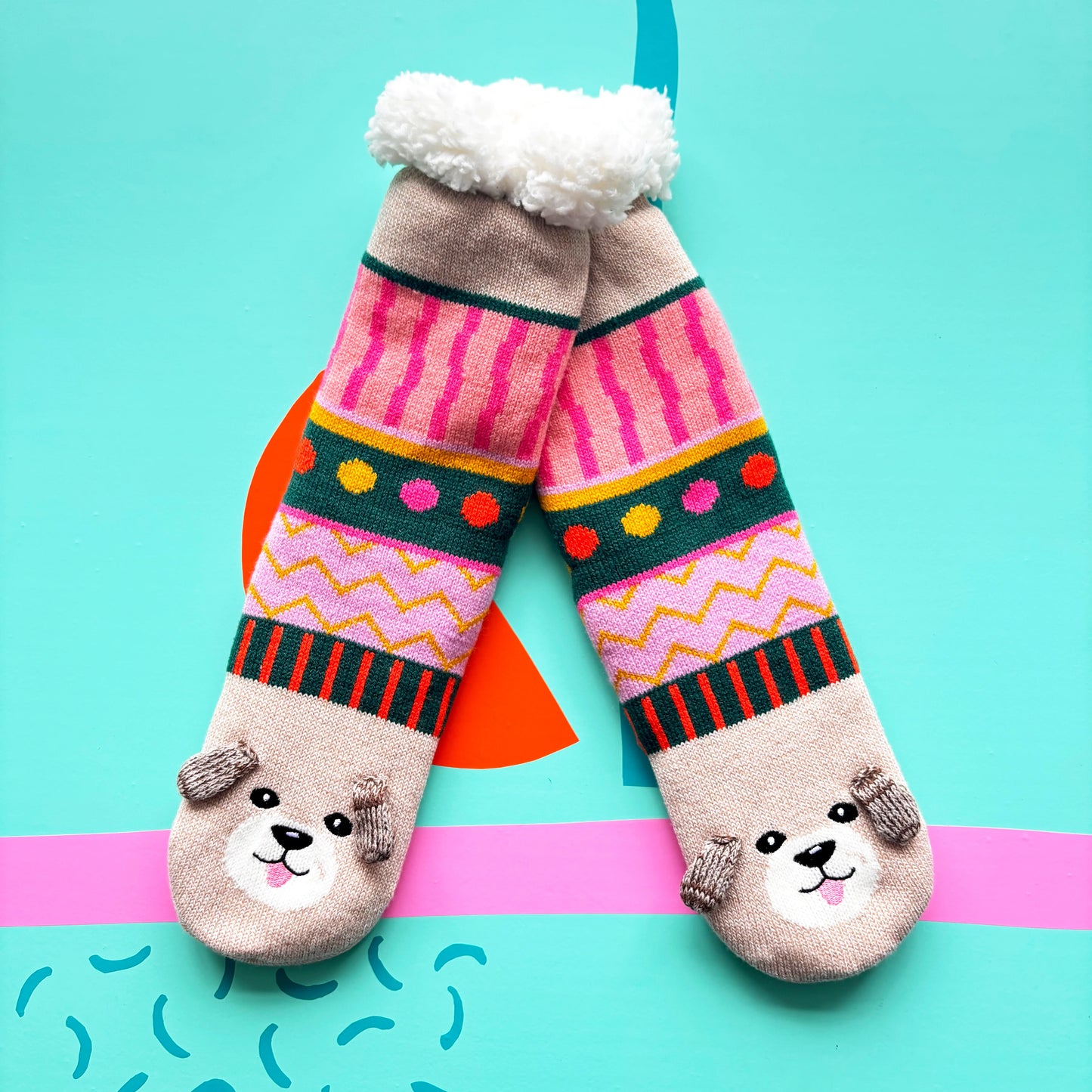 A pair of colourful Dog House Slipper Socks with dog faces and ears on the toes, featuring anti-slip soles and vibrant patterns—an ideal gift for dog lovers, displayed on a blue background.