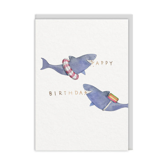 Two illustrated sharks wearing rubber rings adorn a delightful E Frances Paper birthday card, with Happy on one side and Birthday on the other.