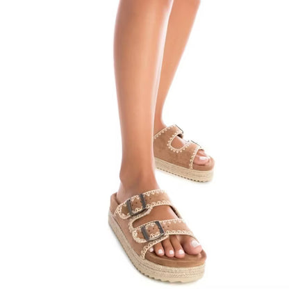 Person wearing tan double-buckle sandals with thick soles and white stitching, standing on a white background. These vegan suede sandals provide comfort and style for any casual outfit.