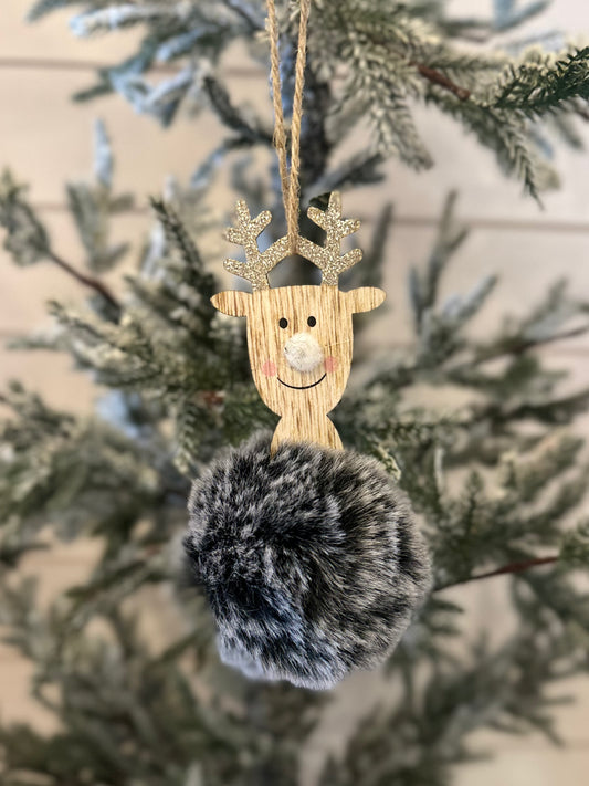 A charming deer decoration with glittery antlers and a fluffy grey pom-pom hangs on a Christmas tree, adding festive holiday décor to your home.