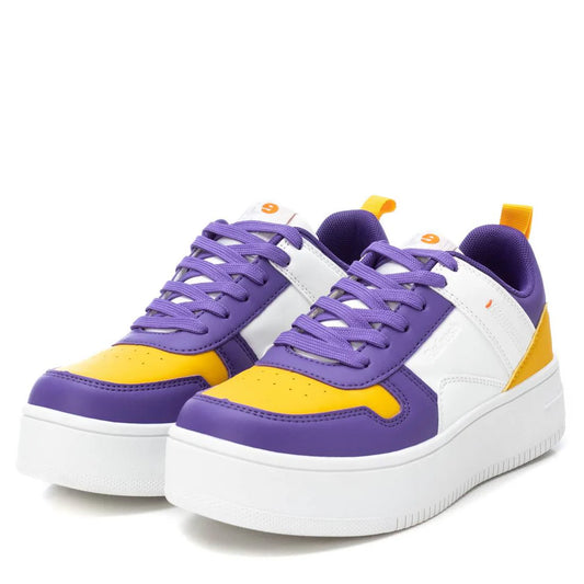 A pair of women's stylish trainers with purple, yellow, and white panels, white soles, and purple laces, made from cruelty-free materials for a chic and ethical appearance.