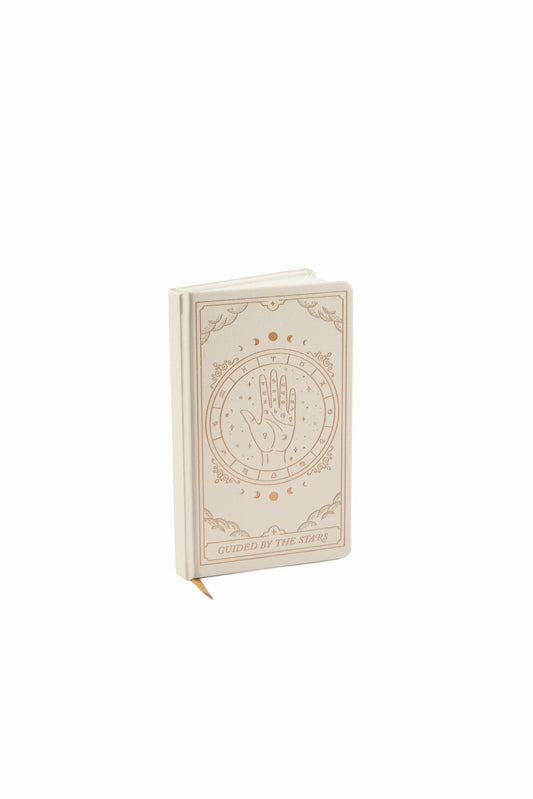 A beige hardback journal adorned with a hand illustration and decorative patterns on the cover, featuring the text Guided by the Stars at the bottom—ideal for enthusiasts of luxury stationery.