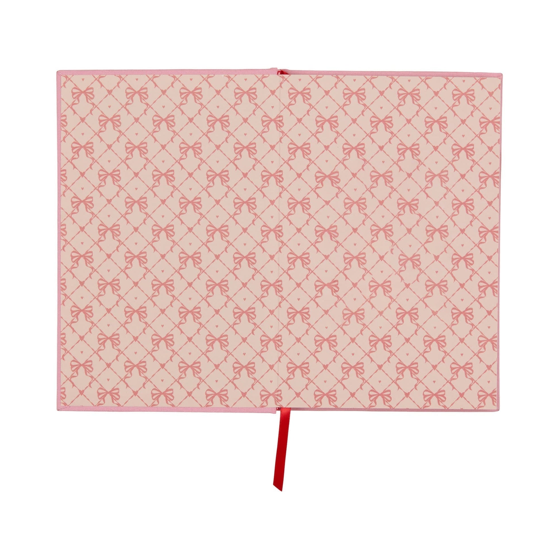 An open lay-flat journal with pink covers and pages displaying a repeating pattern of red bows, along with a red ribbon bookmark positioned in the centre.