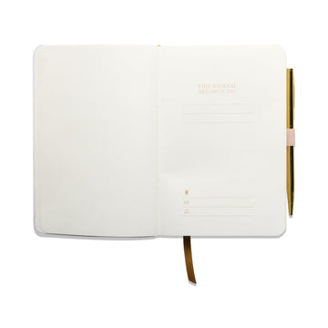 An open, blank mindfulness journal with a gold pen attached to the right-hand side and a gold ribbon bookmark positioned in the centre.