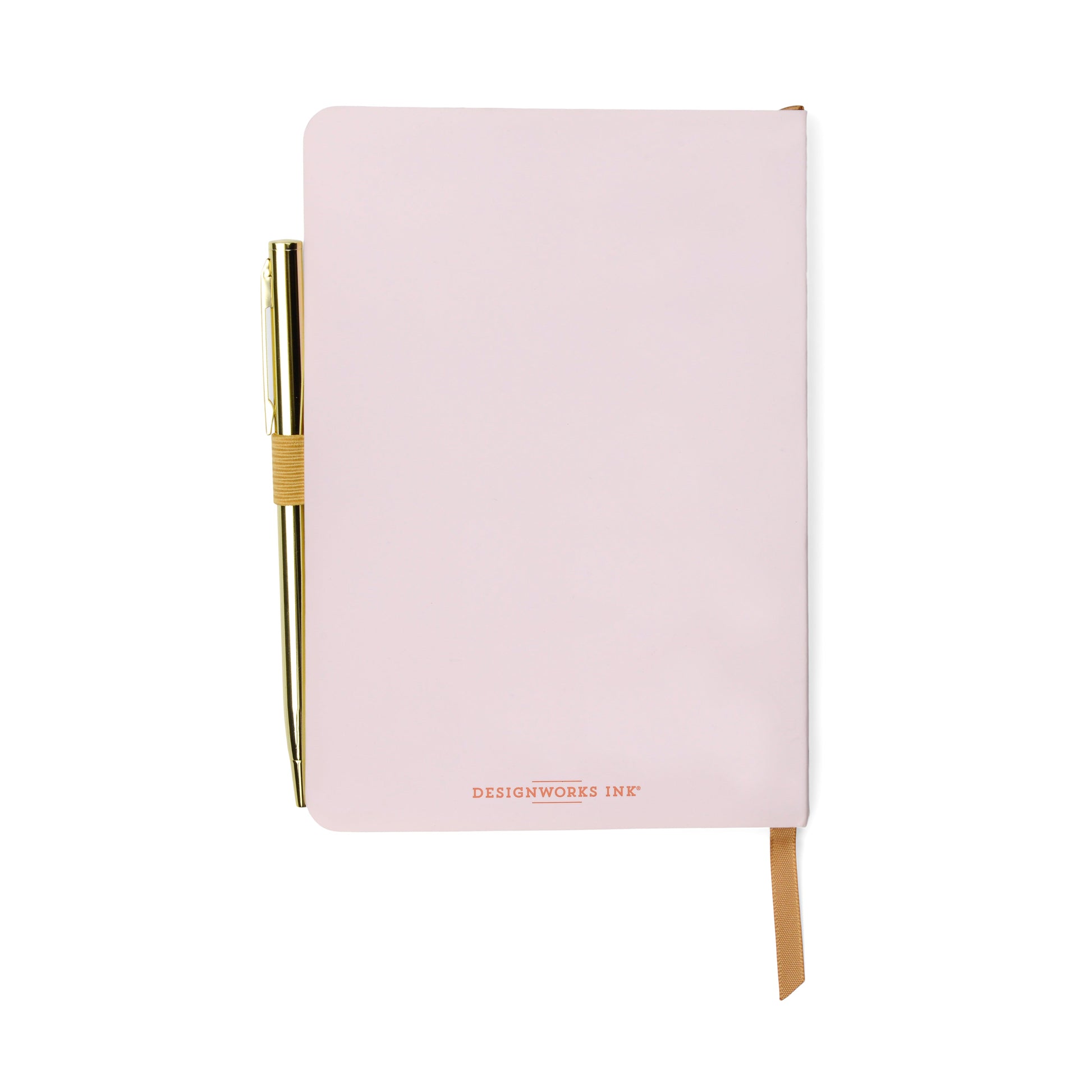 A closed pale pink gratitude journal with DESIGNWORKS INK on the cover, featuring an elastic pen loop holding a gold pen and a tan ribbon bookmark—ideal for your mindfulness or wellbeing routine.