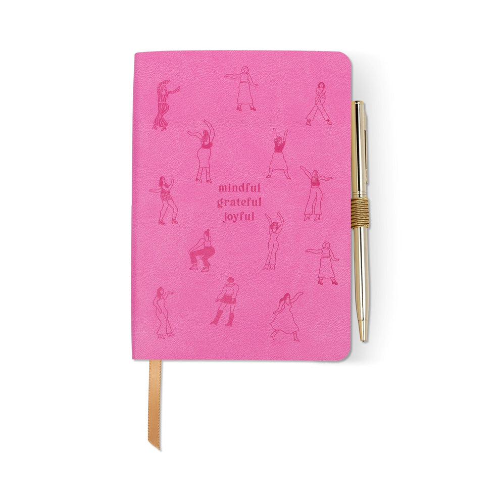 A pink vegan leather mindfulness journal featuring line drawings of people dancing, “mindful grateful joyful” in the centre, a gold ribbon bookmark, and a gold pen attached to the right side.
