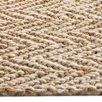 Close-up view of a handmade rug displaying a woven natural fibre design with a braided texture in light beige and tan colours.