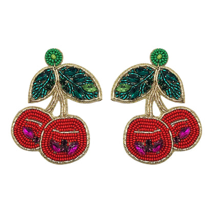 Beaded Crystal Disco Cherry Earrings, shaped like cherries with red fruit, green leaves, and gold accents—an eye-catching statement piece from Narratives The Line.