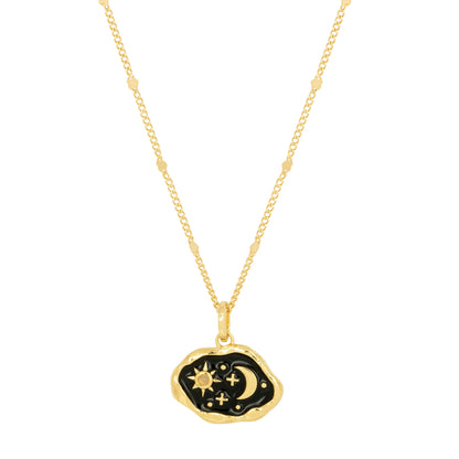 Gold statement necklace with a pendant showcasing a black enamel background adorned with gold sun, moon, and stars, on a delicate beaded chain.