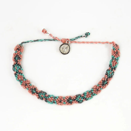 A handwoven macramé bracelet in pink, teal, and black featuring an adjustable knot and a round silver charm—introducing the stylish Leme Surf Bracelet.
