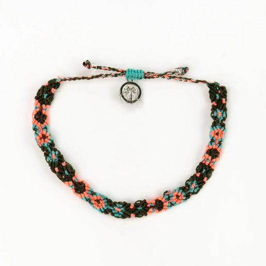 A handwoven macramé bracelet in green, coral, and turquoise threads, featuring a round silver charm at the adjustable fastening—an eco-friendly jewellery piece inspired by the Leme Surf Bracelet.