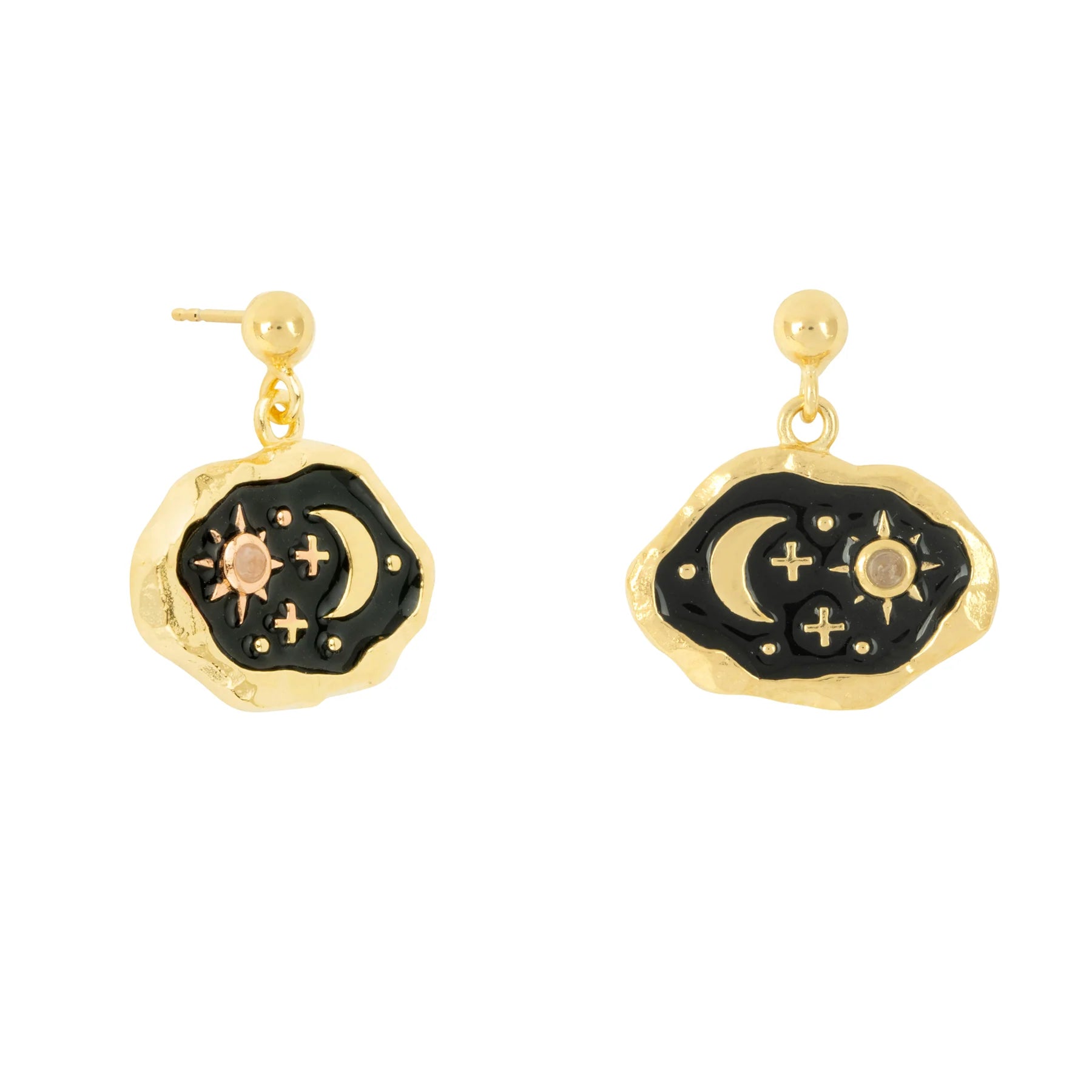 Gold drop earrings with irregular-shaped midnight black enamel centres, adorned with crescent moon, star, and cross designs in gold and silver tones.