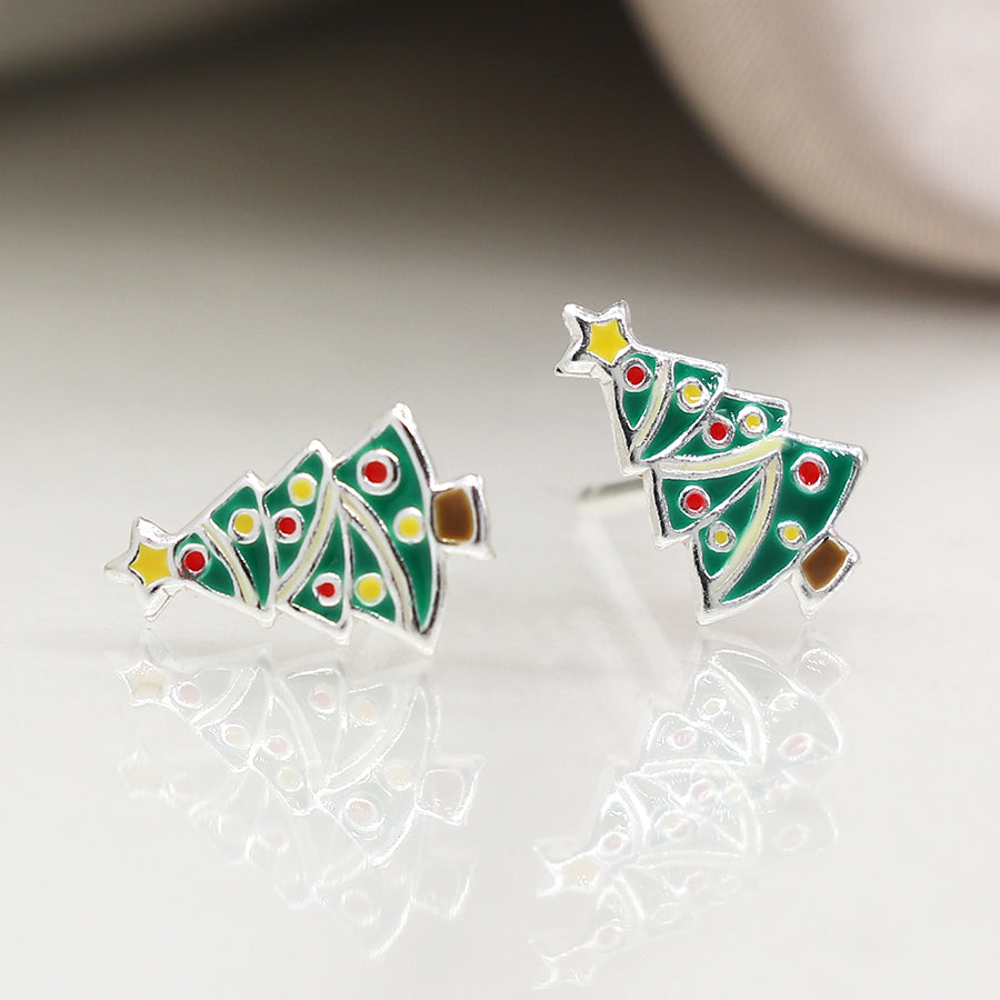 A pair of sterling silver Christmas tree earrings shaped like decorated trees with green enamel, colourful dots, a yellow star, and brown base—the perfect festive earrings for lovers of holiday jewellery.