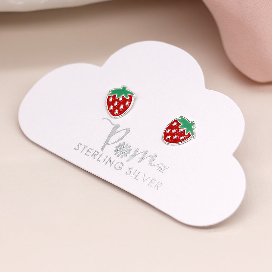 Strawberry-shaped earrings with red and green enamel rest on a cloud-shaped card labelled POM Sterling Silver.