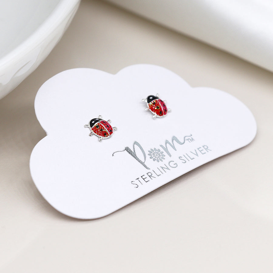 Two handcrafted Enamel Ladybird Earrings rest elegantly on a cloud-shaped card labelled Sterling Silver.