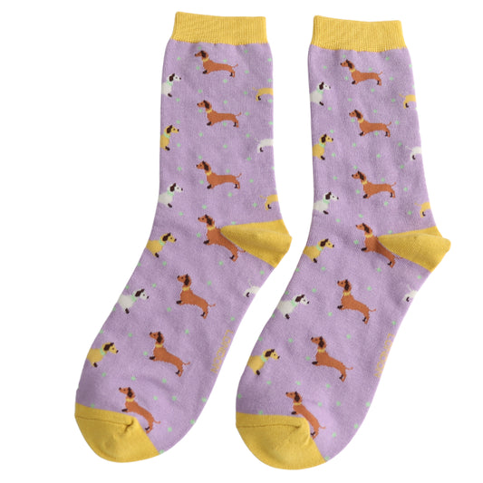 A pair of purple bamboo socks with yellow toes, heels, and cuffs, featuring a pattern of cartoon dogs and small blue spots.