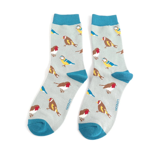Pair of light blue Garden Birds socks with teal toes, heels, and cuffs, featuring a charming bird pattern in red, yellow, brown, and blue. Made from a soft bamboo blend for vegan-friendly comfort.