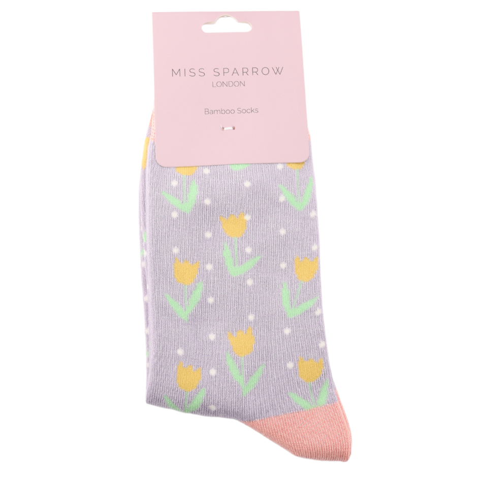 A pair of Tulips Spots Mauve Socks in light purple bamboo and cotton, featuring yellow tulips and white spots, packaged with a pink Miss Sparrow London Bamboo Socks label. Vegan-friendly socks.