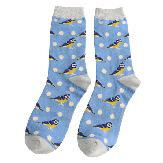 A pair of vegan-friendly blue socks with grey toes, heels, and cuffs, decorated with yellow and blue birds and white polka dot patterns.