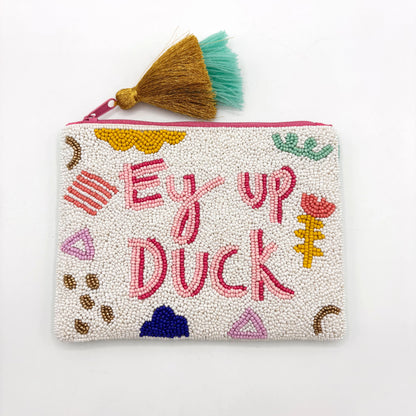 A hand-beaded velvet ‘Ey Up Duck’ pouch featuring colourful patterns, British slang in pink, and a gold and teal tassel on the zip—a cheerful gift celebrating British slang.