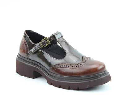 A single brown vegan T-bar brogue with a chunky sole, brogue detailing, and a metal buckle, featuring memory-foam insoles, photographed against a white background.