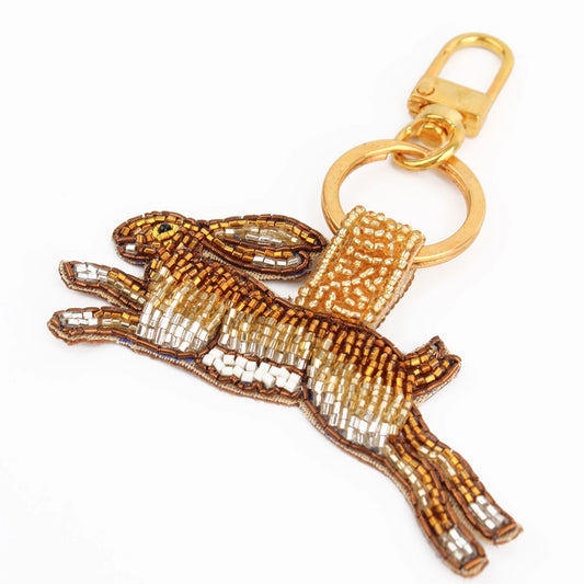 The Golden Hare Keyring is an essential accessory for animal lovers, featuring a beaded hare design with brown, white, and silver beads and a gold clasp.