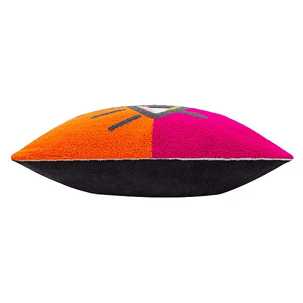 A colourful throw cushion with a black base and a vibrant top displaying orange, pink, and purple sections, accented by abstract stitched lines in the centre.