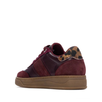 A maroon women’s trainer featuring suede and leather panels, a leopard print detail on the heel, and a brown non-slip sole, seen from the rear side.