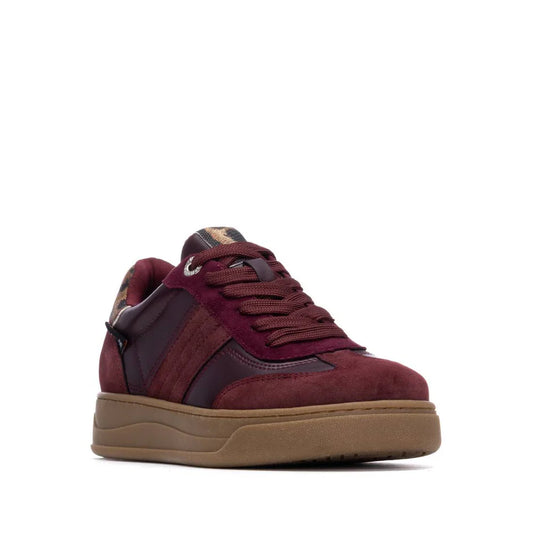 A maroon and burgundy women’s trainer featuring a brown gum non-slip sole, suede and leather detailing, and maroon laces, displayed against a white background.