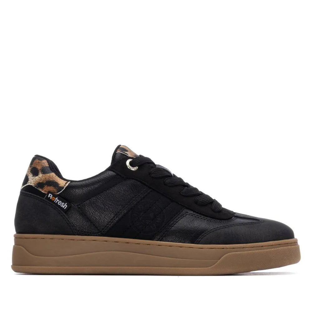 Black trainers with a brown sole, black laces, and leopard print detail by the ankle; fashionable womens trainers made as vegan footwear. Side view against a white background.