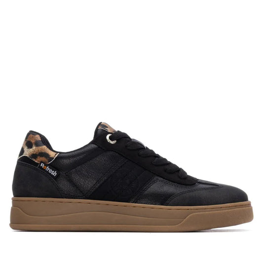 Black trainers with a brown sole, black laces, and leopard print detail by the ankle; fashionable womens trainers made as vegan footwear. Side view against a white background.