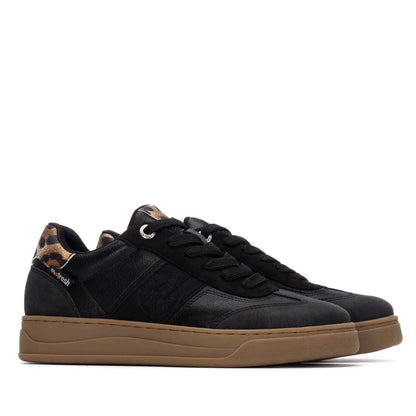 Pair of black vegan trainers with brown soles, black laces, and a leopard print detail on the heel, shown against a white background.