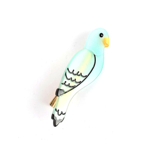 A unique pin shaped like a light blue parrot with black detailing and a yellow beak, perfect as a Parrot Hair Clip or stylish hair accessory against any white background.