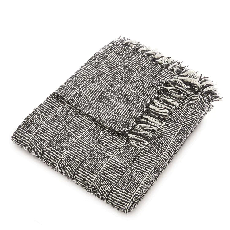 Folded vegan-friendly woven Cross Hatch black throw blanket with fringed edges, made from recycled bottles, shown against a white background.