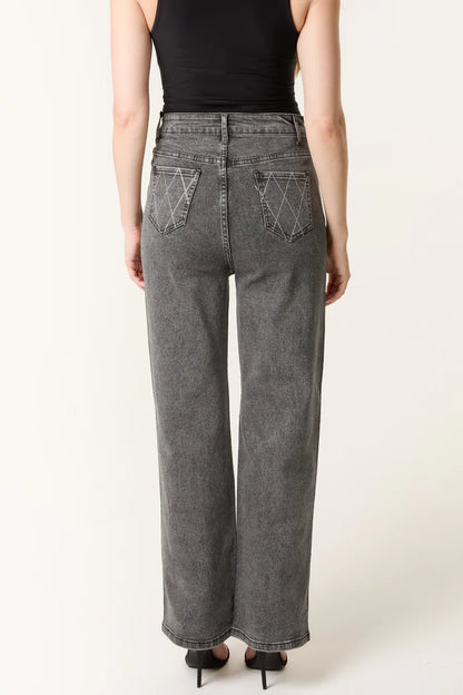 A person wearing a black sleeveless top and high-waisted, wide-leg stretch denim grey jeans with white stitching on the back pockets, seen from behind.