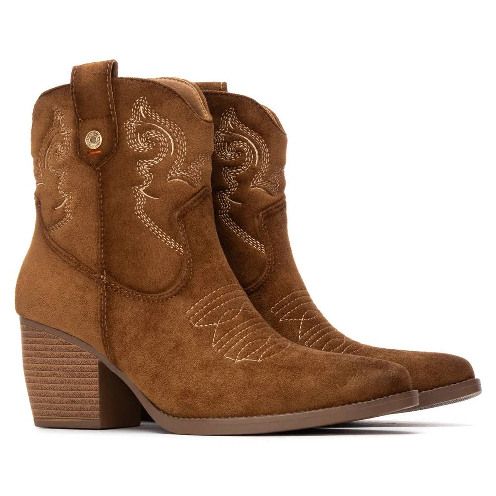 A pair of brown suede women’s cowboy-style boots with decorative stitching, pull tabs, and stacked block heels.