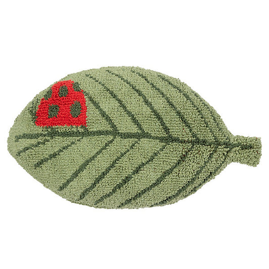A green, leaf-shaped rug with visible veins and a small red ladybird design in the upper left area, perfect as a nature-inspired cushion for any playful space.