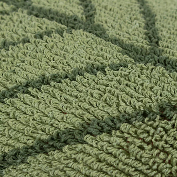 Close-up of textured green knitted fabric featuring a raised, leaf-like pattern, ideal for a nature-inspired cushion.