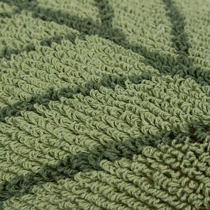 Close-up of textured green knitted fabric featuring a raised, leaf-like pattern, ideal for a nature-inspired cushion.