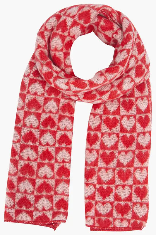 A cruelty-free scarf, knitted with a red and light pink heart pattern arranged in a grid, perfect for staying cosy and stylish throughout the winter.