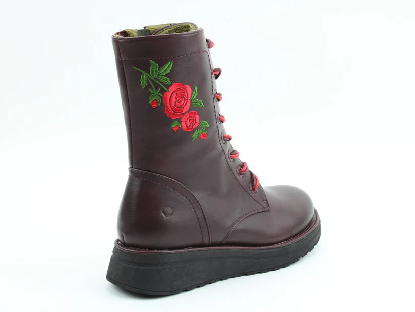 A maroon leather lace-up boot with a black sole, adorned with red rose and green leaf embroidery on the side—these embroidered rose boots provide both style and comfort with a memory foam insole.
